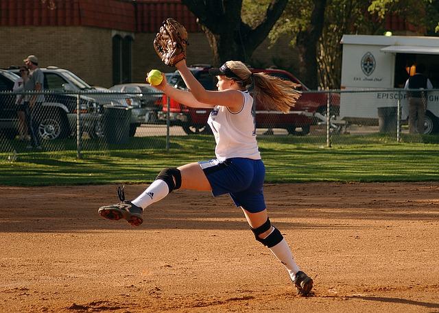 A softball pitcher with long hair.