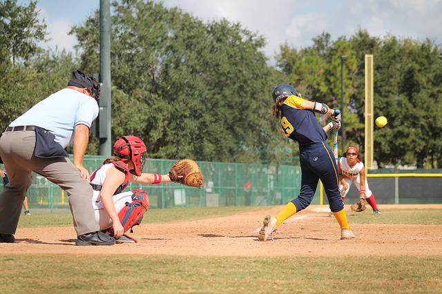 Softball player wearing a protective mask